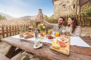 Un hombre toma una fotografía de una pareja desayunando. en La Congosta, mágica aldea rodeada de montañas, en La Plaza 34 fotos más