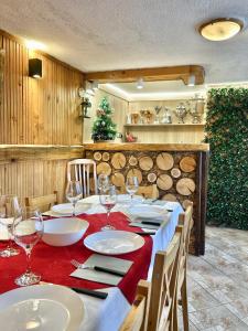 una mesa con copas de vino y un mantel rojo en Guest House Rila, en Govedartsi