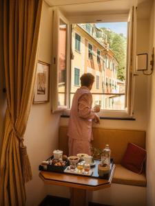 a woman looking out the window of a hotel room at Splendido Mare, A Belmond Hotel, Portofino in Portofino