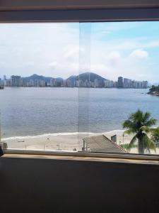 a window with a view of a beach and a city at Jade Beach Club in São Vicente