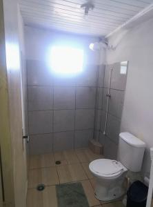 a bathroom with a white toilet and a shower at Jade Beach Club in São Vicente