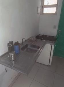 a kitchen with a sink in a room at Jade Beach Club in São Vicente