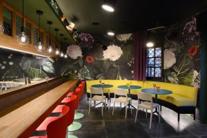 a restaurant with tables and chairs and a floral wall at Franz Apartments in Ilirska Bistrica
