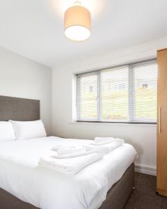 a bedroom with a bed with white sheets and a window at North Devon Resort in Ilfracombe +37 photos