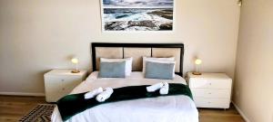 Un dormitorio con una cama con toallas blancas. en Sea Sands Villa, en Fish Hoek