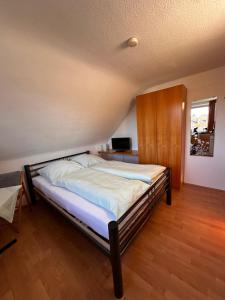 罗埃特根Pension Britta的铺有木地板的客房内一张大床