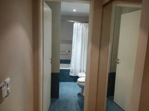 a bathroom with a toilet and a tub and a window at Howard Johnson by Wyndham San Pedro in San Pedro