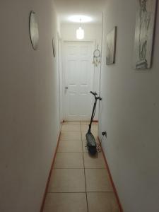 een kamer met een scooter op de vloer voor een deur bij Refugio Alfalfares in La Serena