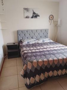 een slaapkamer met een bed met een dekbed erop bij Refugio Alfalfares in La Serena