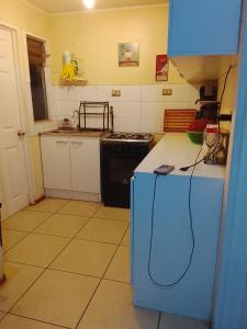 een keuken met een blauwe koelkast en een fornuis bij Refugio Alfalfares in La Serena