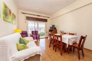 un soggiorno con divano bianco, tavolo e sedie di B56 - Baluarte Cul de Sac Flat in Lagos a Lagos