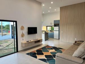 a living room with a couch and a television on a wall at Casa Brisa em Touros in Touros