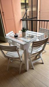 een glazen tafel met twee stoelen en een potplant bij Bon Bon Il Brofferio in Asti