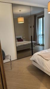 een spiegelbeeld van een slaapkamer met een bed en een spiegel bij Bon Bon Il Brofferio in Asti