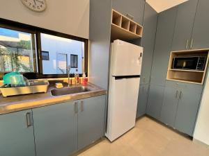 a kitchen with a refrigerator and a sink and a window at Casa Brisa em Touros in Touros