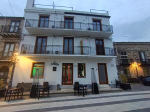 a large white building with tables and chairs in front of it at B&B A' Kiazza in Buompietro