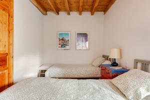 Un dormitorio con dos camas y una mesa con lámpara. en Era Rectoría, en Mont