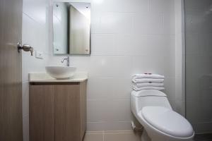 a bathroom with a sink and a toilet and a mirror at Apartahotel Ceo in Medellín +28 photos
