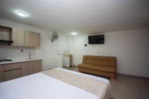 a bedroom with a bed and a couch in it at Apartahotel Ceo in Medellín