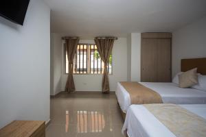 a hotel room with two beds and a window at Apartahotel Ceo in Medellín