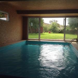 einen Pool in einem Haus mit einem großen Fenster in der Unterkunft La Verrière - maison écologique normande 