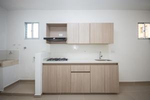 uma cozinha com armários de madeira e uma pia em Apartahotel Ces em Medellín