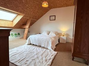ein Schlafzimmer mit einem großen Bett im Dachgeschoss in der Unterkunft La Verrière - maison écologique normande  + 18 Fotos