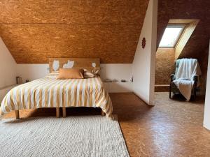 ein Schlafzimmer mit einem großen Bett im Dachgeschoss in der Unterkunft La Verrière - maison écologique normande  + 18 Fotos