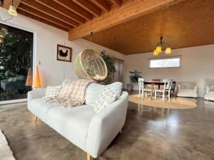 ein Wohnzimmer mit Sofa und Tisch in der Unterkunft La Verrière - maison écologique normande 