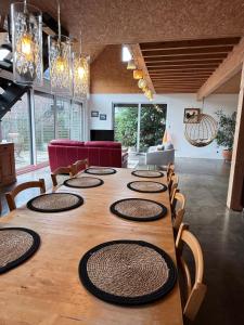 ein großer Holztisch mit Stühlen und ein großes Zimmer in der Unterkunft La Verrière - maison écologique normande 