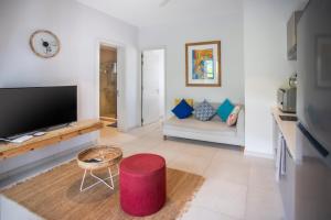 een woonkamer met een tv en een bank bij Luxury Beachfront Apt - Perfect for Beach Lovers in Rivière Noire