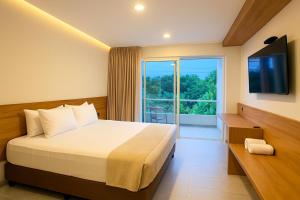 a hotel room with a bed and a large window at Stanza Del Mar in Coveñas