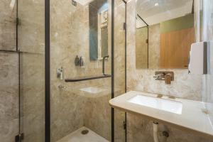 ein Badezimmer mit Waschbecken und Dusche in der Unterkunft Tripli The Pinakin Stays in Varanasi