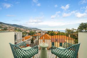 a balcony with two chairs and a view of a city at Casa NOLA by Susys Holidays in Funchal