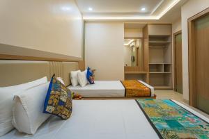 ein Schlafzimmer mit zwei Betten und einem Kleiderschrank in der Unterkunft Tripli The Pinakin Stays in Varanasi