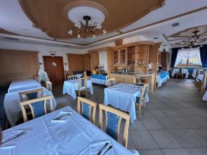 a restaurant with blue tables and chairs and a kitchen at Hotel Alpe Bellaria in Candriai