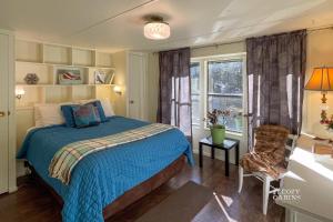 a bedroom with a bed and a chair and a window at Ruidoso Mountain Getaway Centrally Located in Ruidoso