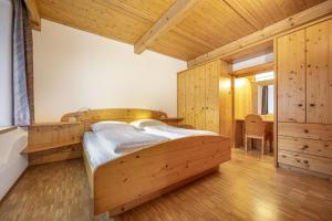 een slaapkamer met 2 bedden in een kamer met houten wanden bij Apartments Romy in Ortisei