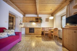 een woonkamer met een roze bank en een tafel bij Apartments Romy in Ortisei