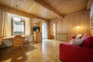 een woonkamer met een rode bank en een tafel bij Apartments Romy in Ortisei