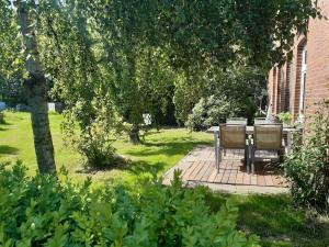 a patio with a table and chairs in a yard at Schöner alter Resthof am Jadebusen in Reitland