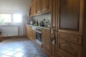 a kitchen with wooden cabinets and a stove top oven at Schöner alter Resthof am Jadebusen in Reitland