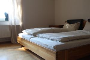 a unmade bed in a room with a window at Schöner alter Resthof am Jadebusen in Reitland