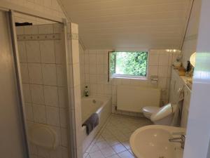 a bathroom with a tub and a sink and a toilet at Schöner alter Resthof am Jadebusen in Reitland