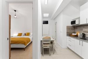 a bedroom with a bed and a kitchen with a table at Artistas House in Aveiro