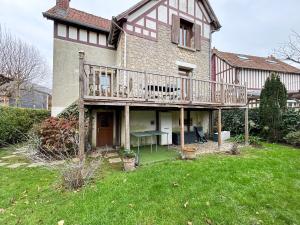 ein großes Haus mit seitlicher Terrasse in der Unterkunft Maison avec jardin dans le centre de Cabourg in Cabourg