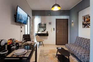 a living room with a couch and a table and a tv at Agnanti Apartment in Agrinio