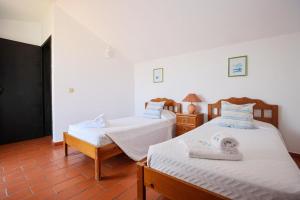 twee bedden in een kamer met witte muren en houten vloeren bij B46 - Belavista Torraltinha Flat in Lagos +44 foto's