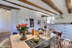 una cucina con tavolo e fiori in vaso di Quinfromel a Pleumeleuc