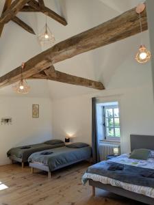 2 letti in una camera con pavimenti e travi in legno di Quinfromel a Pleumeleuc